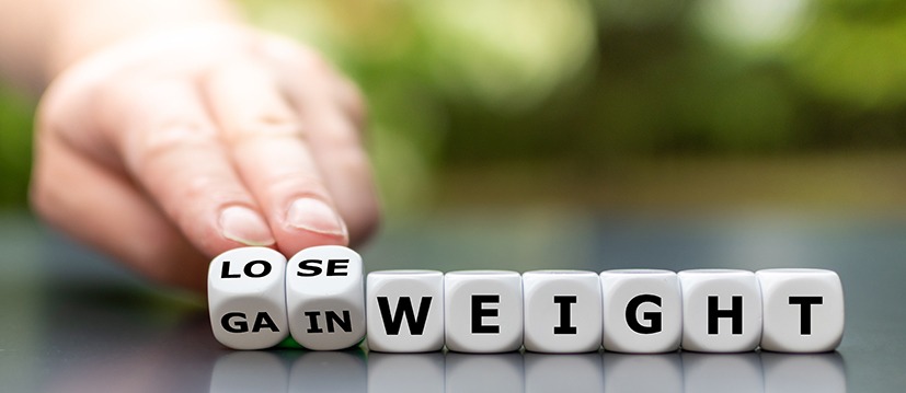 Hand turns dice and changes the expression "gain weight" to "lose weight"
