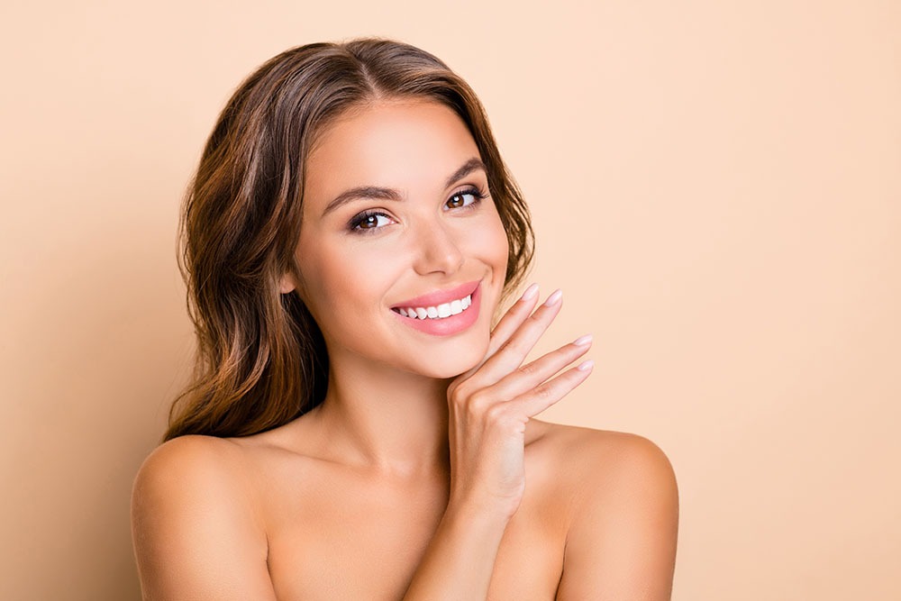 Photo of nice long hairdo optimistic lady without clothes hand face isolated on pastel beige color background